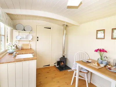 a kitchen with a table and a stove at Bramble in Wadebridge