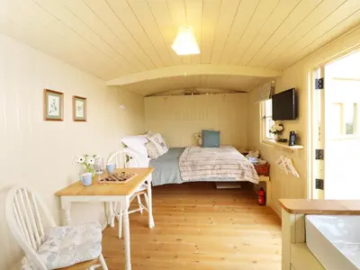 a small bedroom with a bed and a table at Willow in Wadebridge