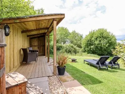 a wooden deck with chairs and a table at Willow in Wadebridge