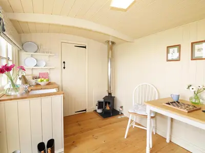 a kitchen with a table and a stove in a room at Willow in Wadebridge