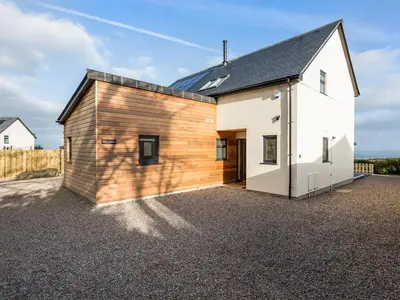 a house clad in wood with a gravel driveway at Chy Lowen in St Ives