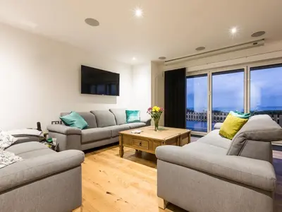 a living room with two couches and a table at Chy Lowen in St Ives