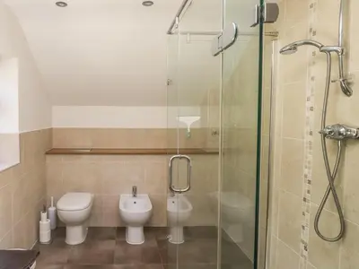 a bathroom with a toilet and a glass shower at Meadow Lea in Liskeard
