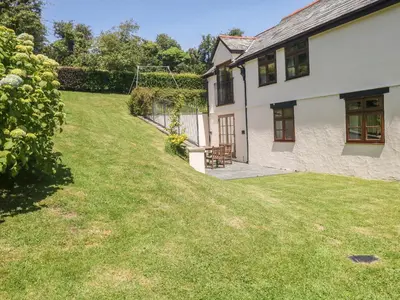 a backyard of a house with a grass yard at Meadow Lea in Liskeard