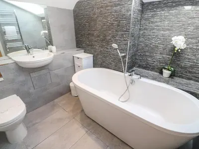 a bathroom with a tub and a toilet and a sink at Seafield in Carbis Bay