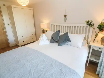 a bedroom with a large white bed with blue pillows at Seafield in Carbis Bay
