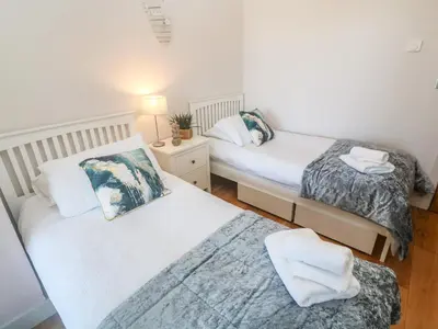 a bedroom with two beds and a night stand at Seafield in Carbis Bay