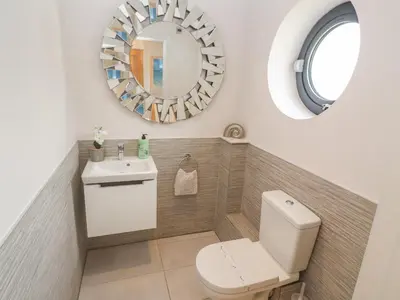 a bathroom with a toilet and a mirror at Seafield in Carbis Bay