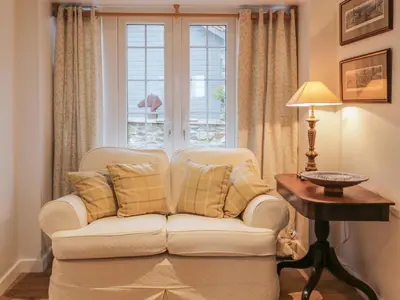 a living room with a couch and a window at The Coach House in Bodmin