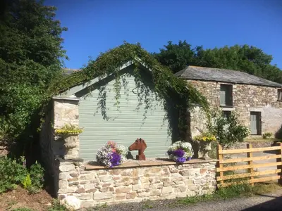 a building with a horse on a stone wall at The Coach House in Bodmin