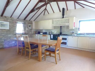 a kitchen with a wooden table and chairs at The Granary in Saint Erth