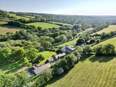 an aerial view of a house in a field at Kingfisher Cabin, Butterwell Farm, Riverside cabin on 40-acre private estate in Bodmin