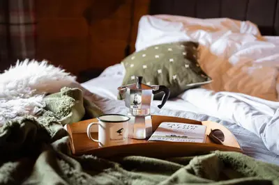 a tray with a coffee maker and a cup on a bed at Kingfisher Cabin, Butterwell Farm, Riverside cabin on 40-acre private estate in Bodmin