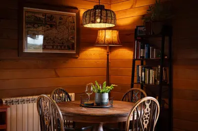 a dining room table with chairs and a lamp at Kingfisher Cabin, Butterwell Farm, Riverside cabin on 40-acre private estate in Bodmin