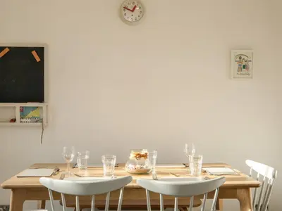 a dining room table with chairs and a clock on the wall at Rockpool in Padstow