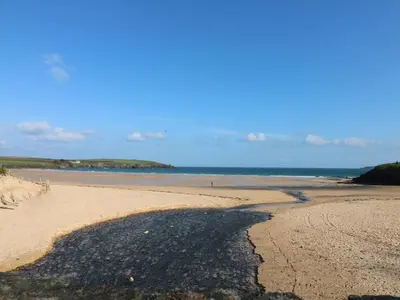 a beach with a large shadow on the sand at Rockpool in Padstow