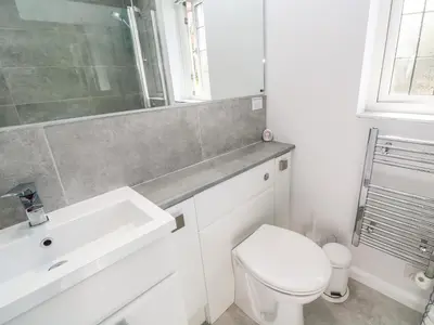a white bathroom with a sink and a toilet at Rockpool in Padstow