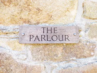 a sign that reads the fountain on a stone wall at Parlour Cottage in Saint Erth