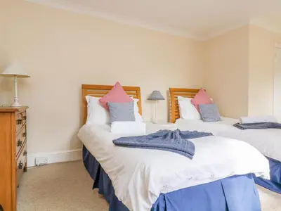 two beds in a room with white and blue at Goshen Farm in St. Agnes