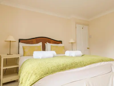 a bedroom with a large bed with a green blanket at Goshen Farm in St. Agnes