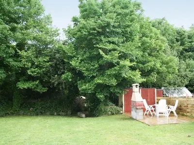 a yard with two chairs and a bird house at Godrevy Cottage in Hayle