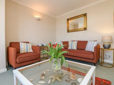 a living room with two couches and a glass coffee table at Sea Star in Porthleven