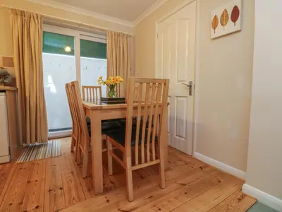 a dining room with a table and chairs and a window at Sea Star in Porthleven