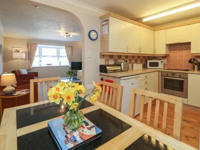 a kitchen with a table with a vase of flowers at Sea Star in Porthleven