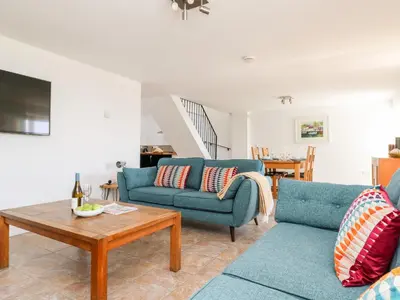a living room with two blue couches and a table at Black Rock in St Austell