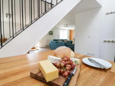 a plate of cheese and grapes on a table in a living room at Black Rock in St Austell