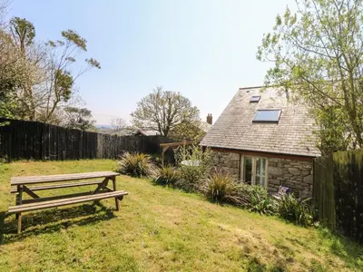 a bench in a yard next to a house at Black Rock in St Austell