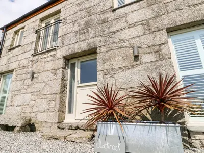 a stone building with two potted plants in front of it at Black Rock in St Austell