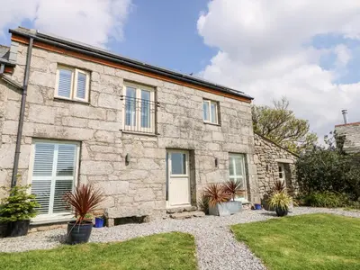 a stone house with a garden in front of it at Black Rock in St Austell