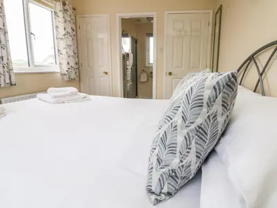 a white bed with a pillow on top of it at Pentewan in Hayle