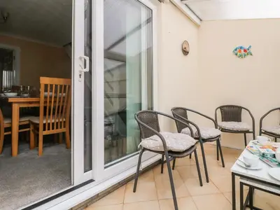 a room with a sliding glass door with chairs and a table at Pentewan in Hayle