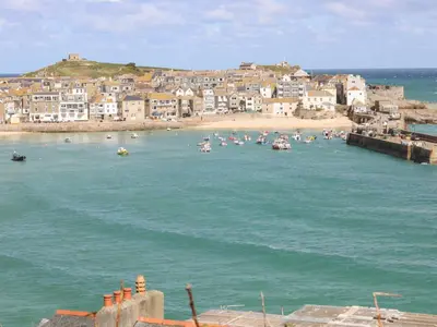 a group of boats in the water near a beach at Pentewan in Hayle
