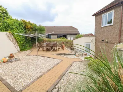 a garden with a patio with a table and chairs at Pentewan in Hayle