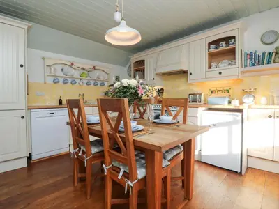 a kitchen with a wooden table and chairs at Trehan in St Ives