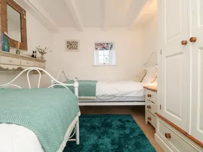 a small bedroom with a bed and a mirror at Trehan in St Ives
