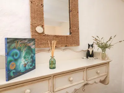 a mirror on top of a dresser with a book at Trehan in St Ives