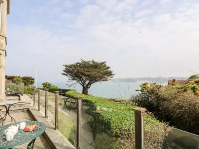 a balcony with a table and a view of the water at By The Sea in Newquay