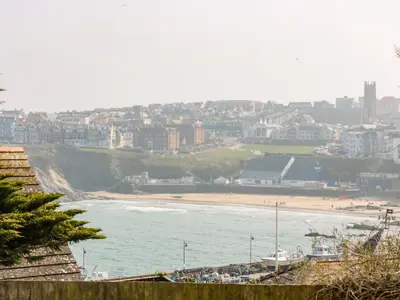 a view of a beach with a city in the background at By The Sea in Newquay
