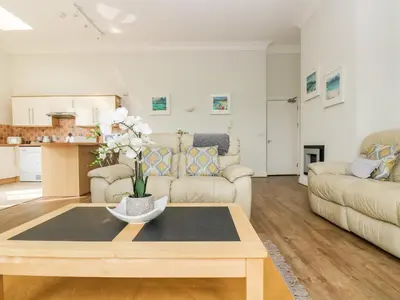 a living room with a table and a couch at By The Sea in Newquay
