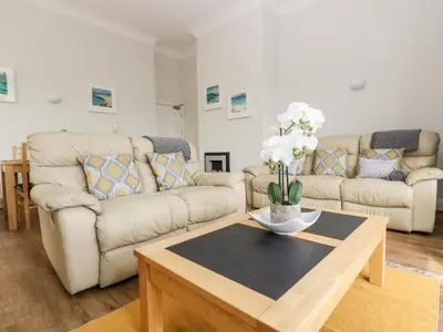 a living room with two couches and a coffee table at By The Sea in Newquay