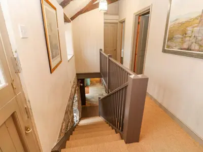 a staircase in a home with a painting on the wall at Barn Cottage in Saint Erth
