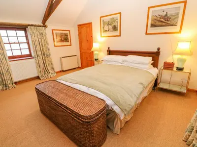 a bedroom with a large bed and a window at Barn Cottage in Saint Erth