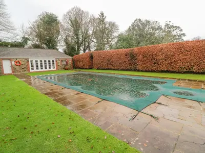 a swimming pool in the yard of a house at Barn Cottage in Saint Erth