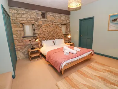 a bedroom with a bed with towels on it at Barn Cottage in Saint Erth