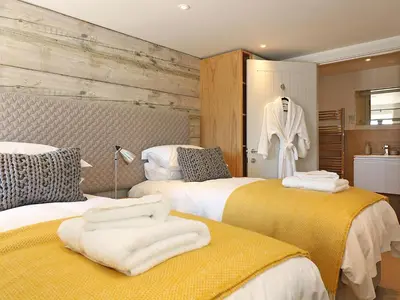 a hotel room with two beds with towels on them at Mill House, Boskensoe Barns in Falmouth