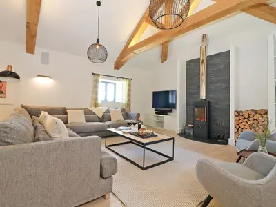 a living room with a couch and a table at Mill House, Boskensoe Barns in Falmouth